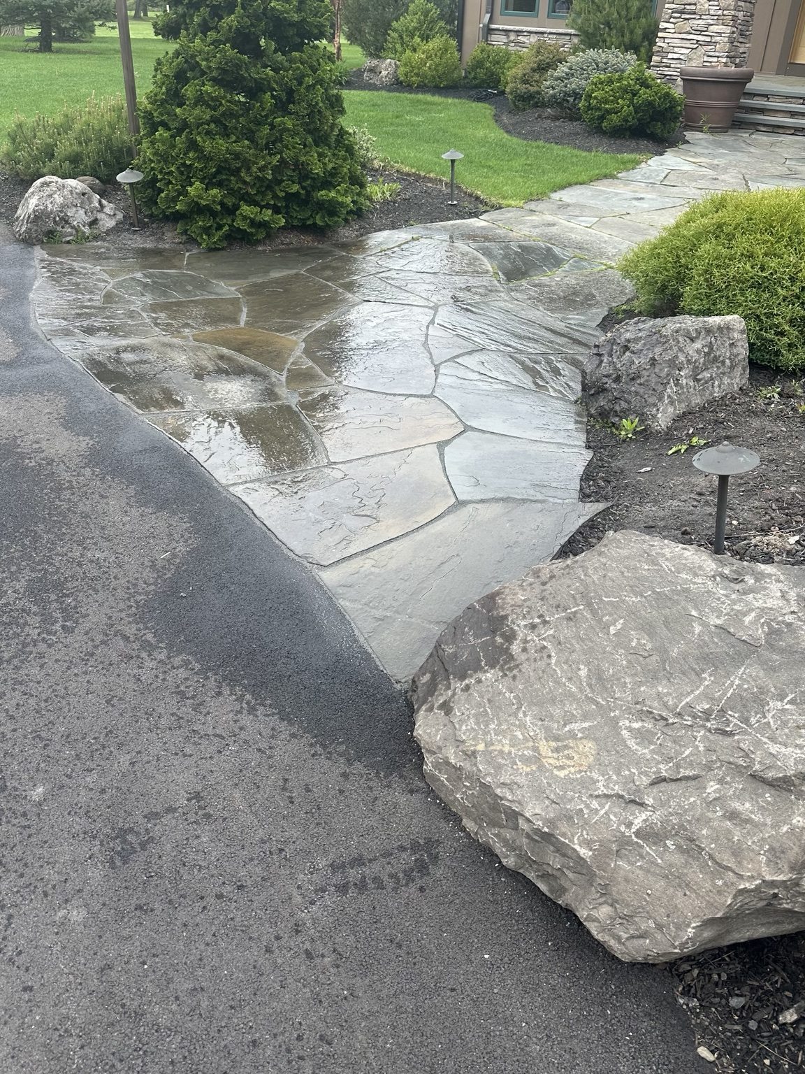 Natural stone steps and boulders along a driveway